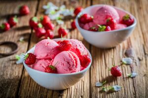 Две миски с розовым мороженым и клубникой