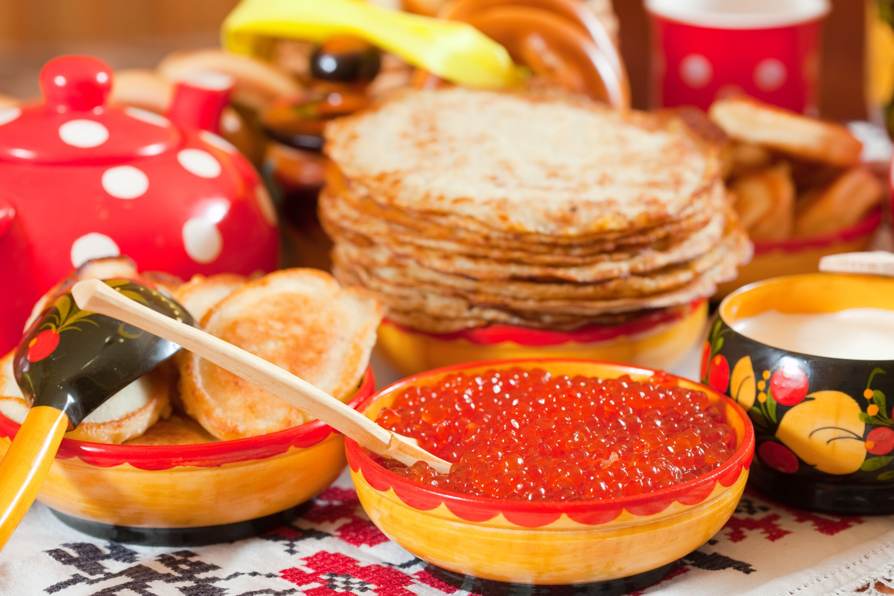 Традиционные русские блины с красной чашкой и деревянной ложкой