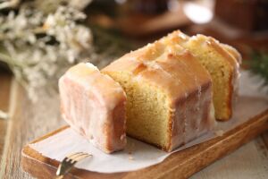 Вкусное лакомство: пирог с бисквитом, покрытый лимонным сиропом и украшенный кокосом