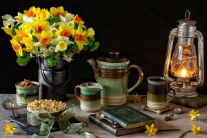 Книга, ложка, чашка с крышкой, чашка без крышки, ваза с цветами, лампа, цветы на переднем плане