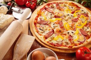 Итальянская пицца с колбасой пепперони, беконом, грибами, помидорами, зелёным перцем и сыром