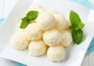 Нежное лакомство: белые кокосовые конфеты, разложенные на тарелке, выглядят как облако сливочной сладости