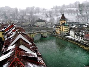 Зимнее очарование старинного города Берна, отражающегося в спокойных водах реки