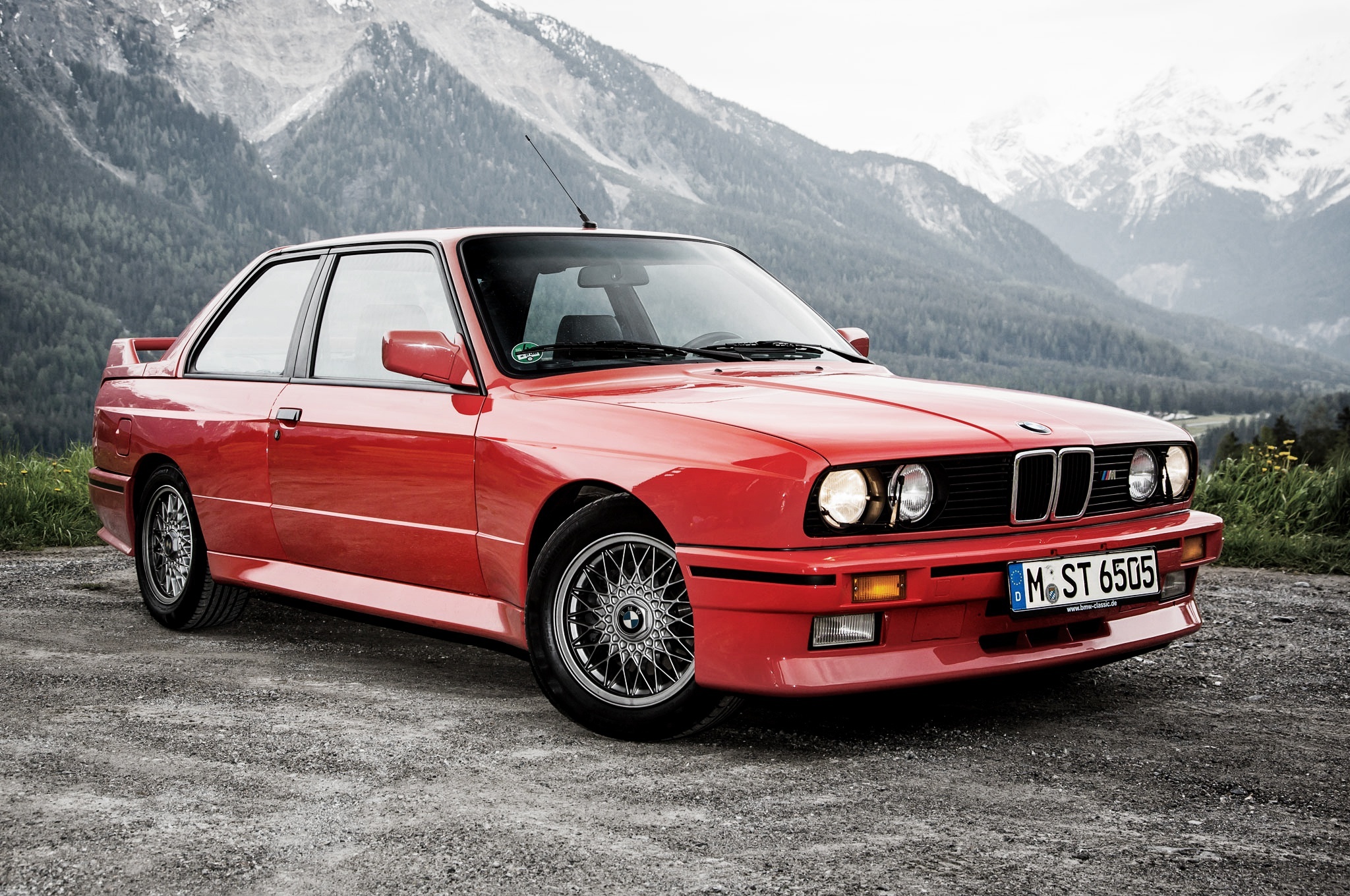Яркий красный BMW E30 купе, заснеженные горы, винтажный стиль