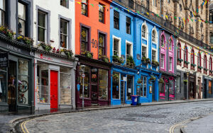 Яркая брусчатка Эдинбурга с красочными домами и витринами магазинов