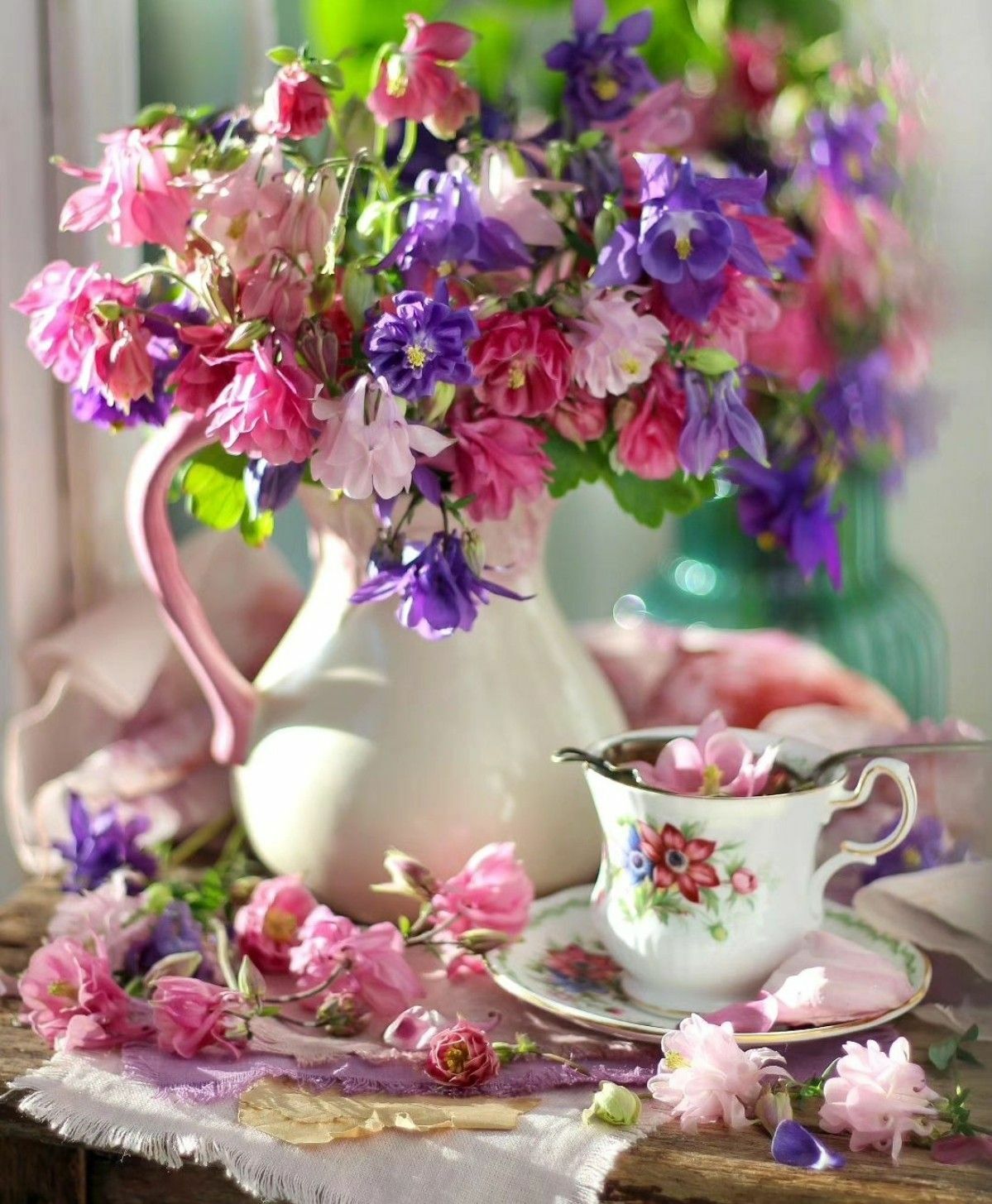 Разноцветные цветочки в кувшине и чашка