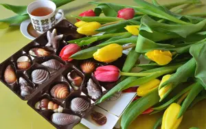 Конфеты, чай и букет тюльпанов